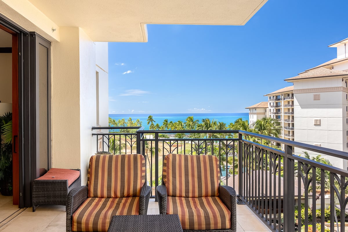 Lanai seating overlooking palms and the Pacific